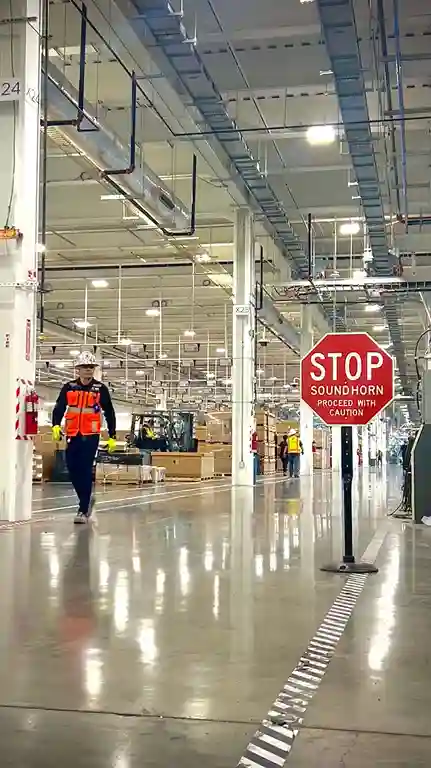 Engineer with safety helmet supervising production line workflow